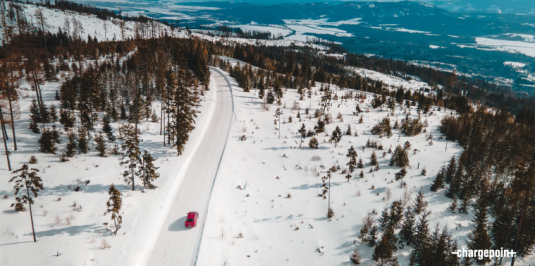 Aerial view of car driving on a snowy road