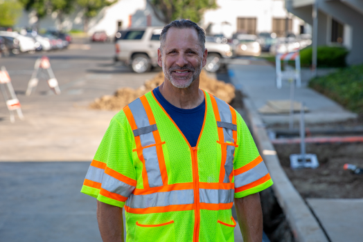 A worker in a neon safety vest at a construction site.