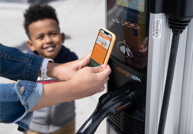 Person using ChargePoint Tap to charge and a kid looking at it